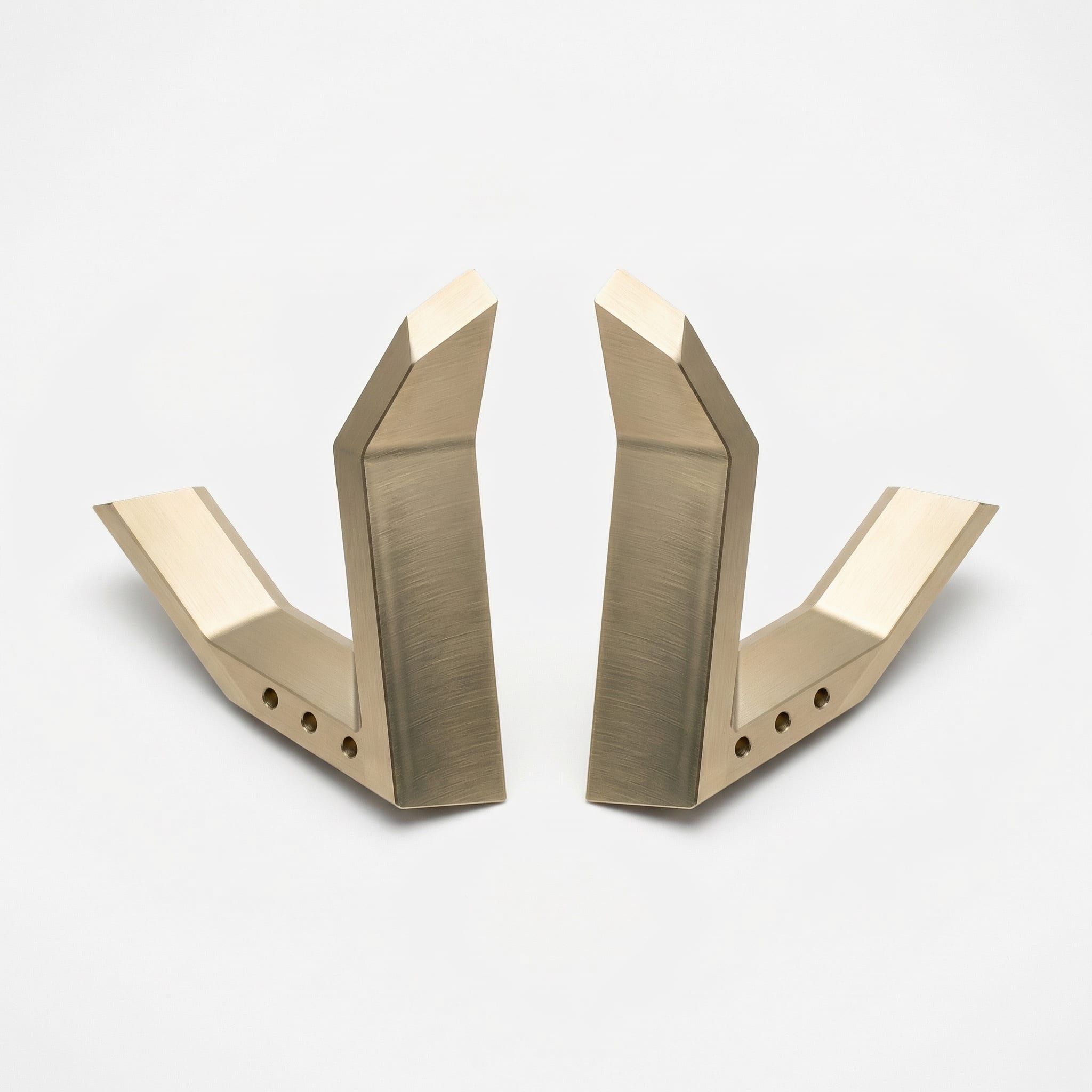 Two bronze-finished CNC-machined brackets on a white background (render)