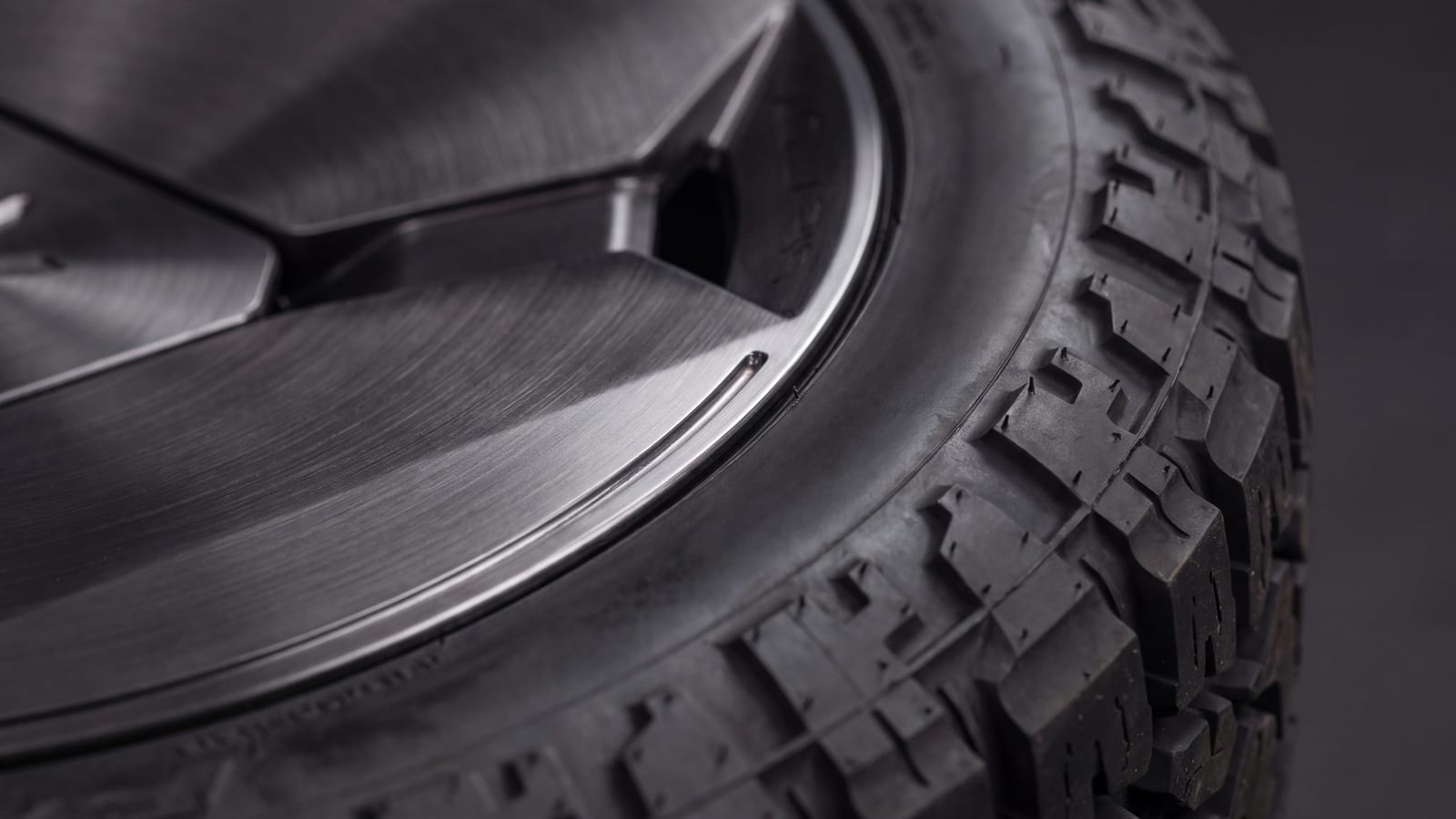 All-terrain tire mounted on a forged wheel, close-up of the tread and sidewall (render)